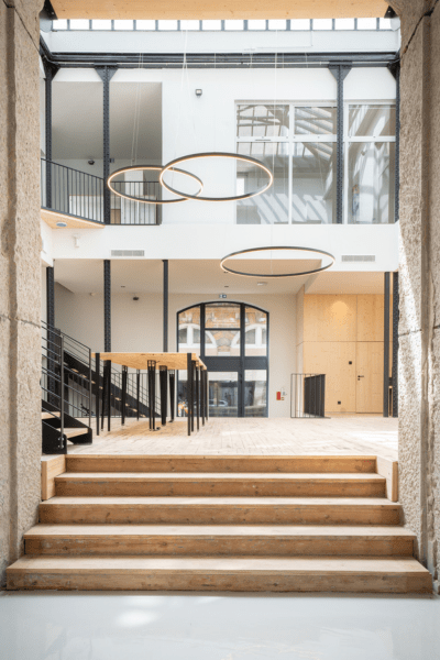 Réalisation des nouveaux bureaux d’ARKIN dans un bâtiment de 1909 à Saint-Étienne : un chantier technique exécuté avec précision selon les plans de l’agence, alliant démolition, plâtrerie, peinture, cloisons modulaires et finitions soignées entre matériaux.